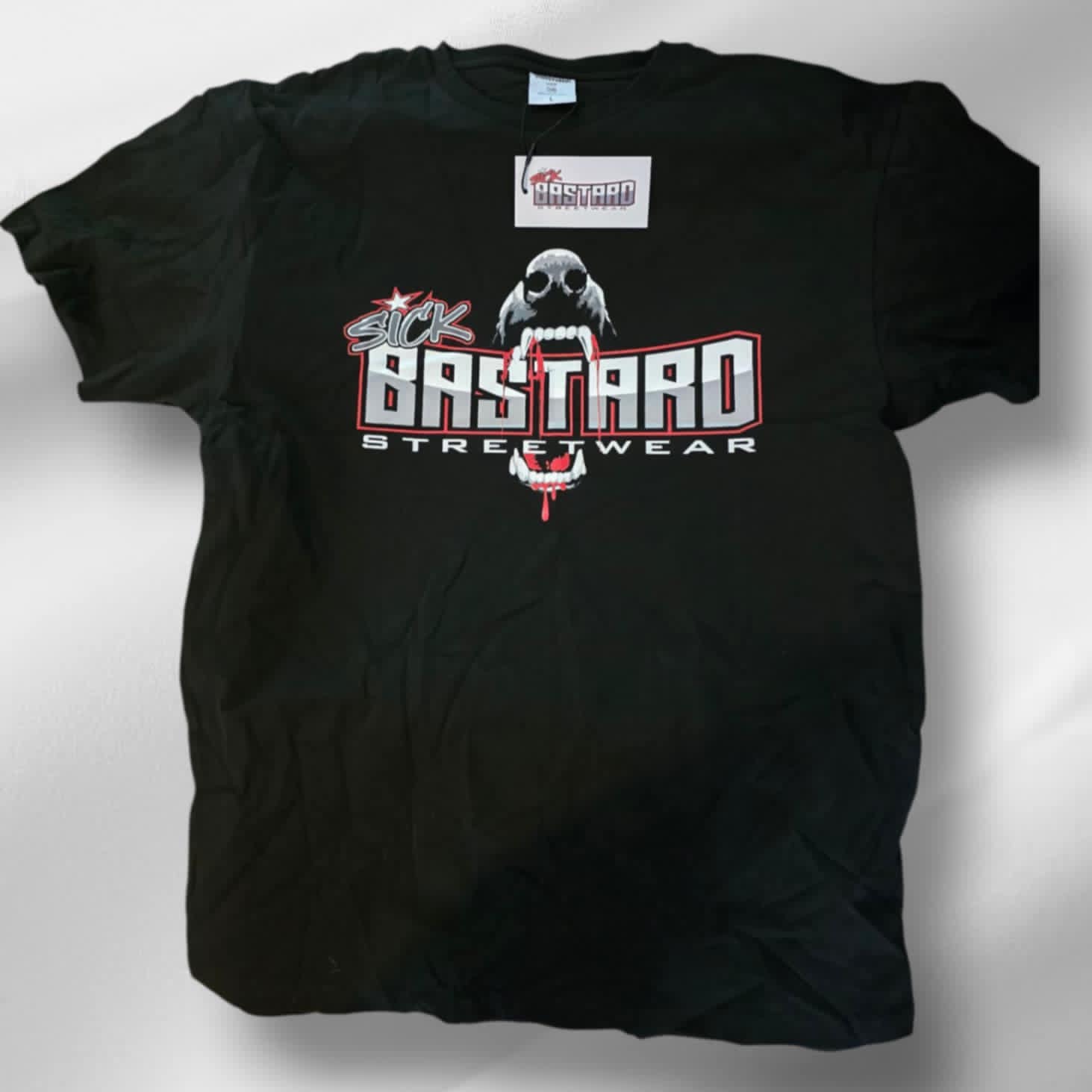 Jet black Sick Bastard Streetwear t-shirt with graphic front print featuring logo, fang-bearing skull, and dripping red detail.