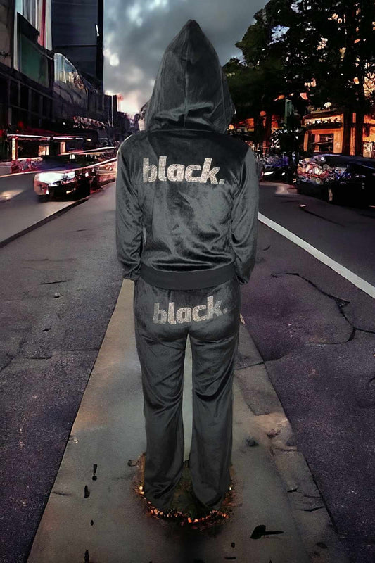 black velour track jacket clearance sale displayed on a model in a city setting, featuring a hoodie and rhinestones.