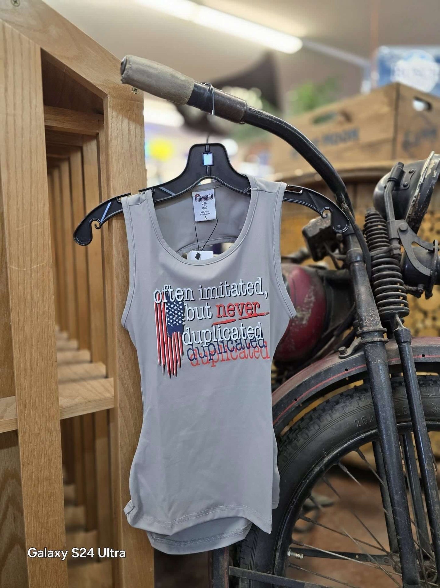 Woman wearing "Often Imitated, Never Duplicated" backless tank top with distressed American flag and racerback design from Sick Bastard Streetwear