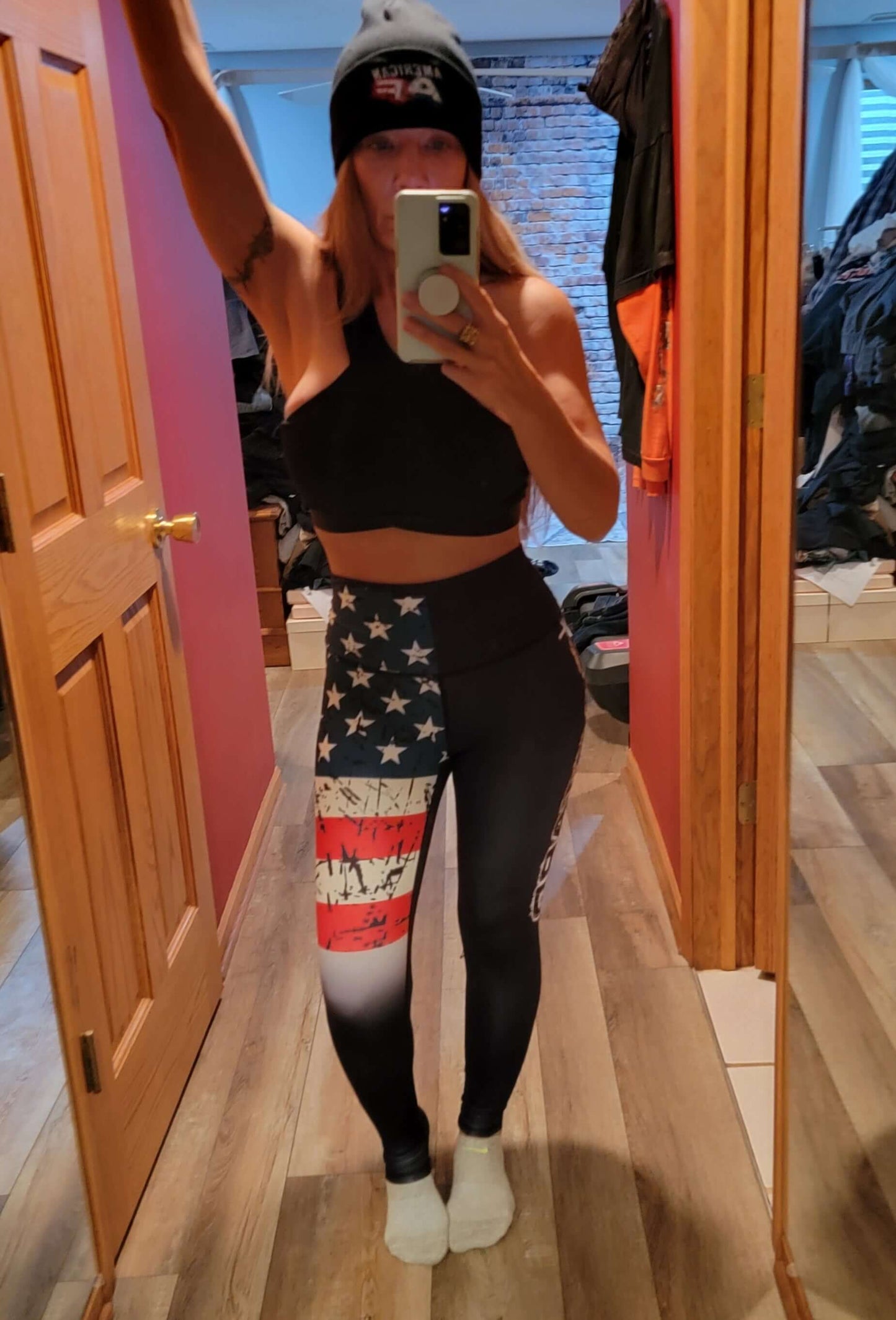 Woman wearing patriotic leggings featuring red, white, and blue design with American flag motifs.