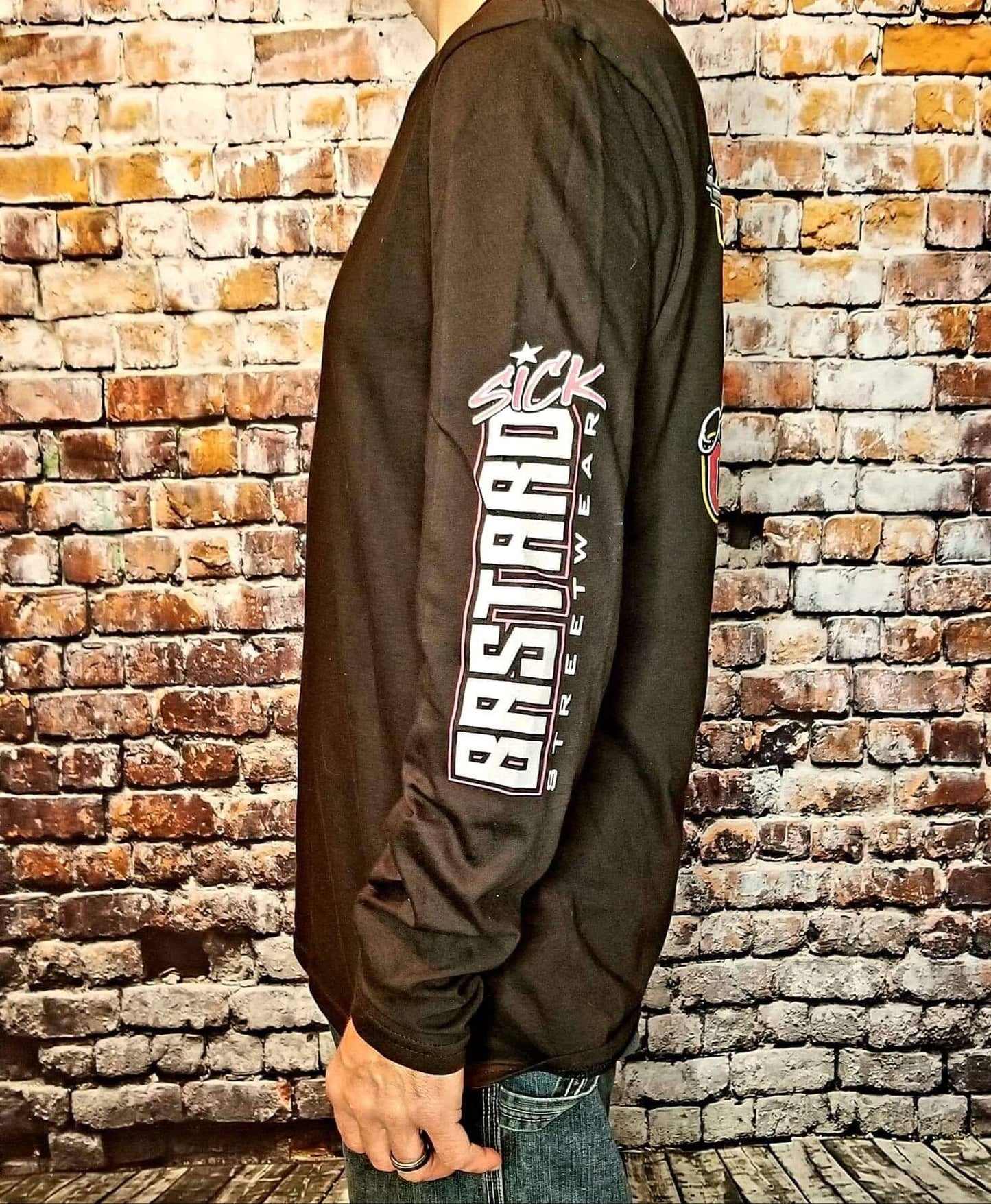 Freedom long sleeve shirt displayed on a model against a brick background, featuring bold graphics and a relaxed fit.