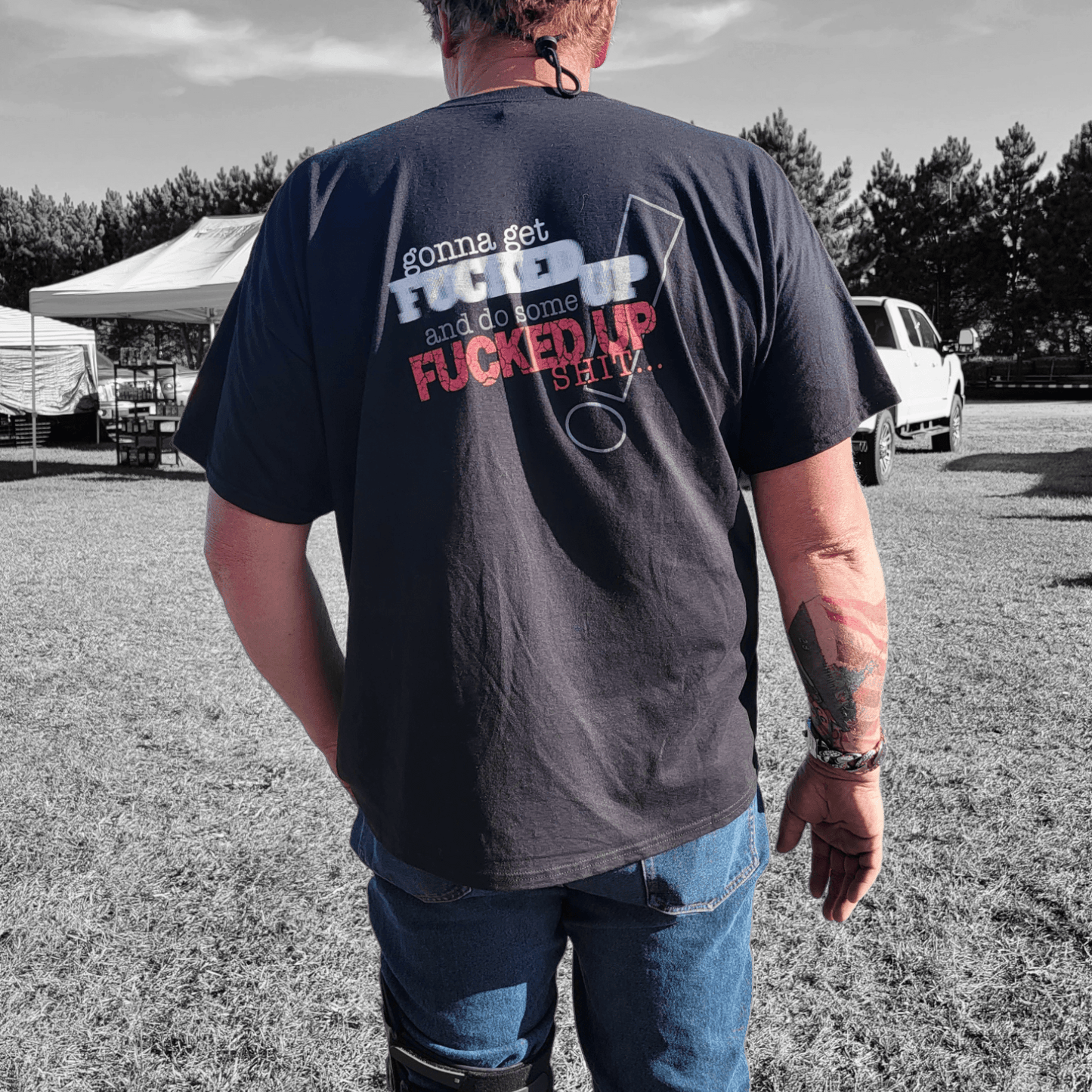 Back view of a man wearing a funny graphic t-shirt that says 'gonna get Fucked up and do some Fucked up Shit'.