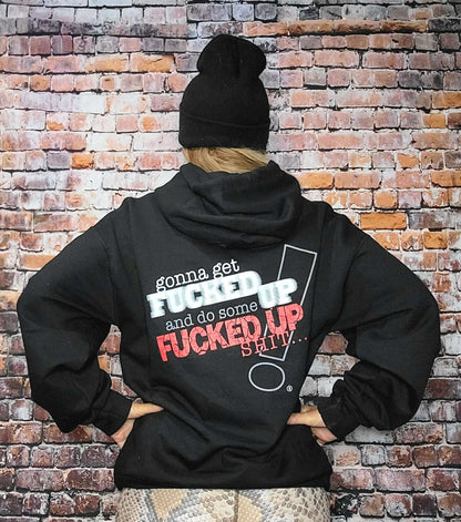 Back view of person wearing a Fucked Up hoodie with bold text on a brick background.