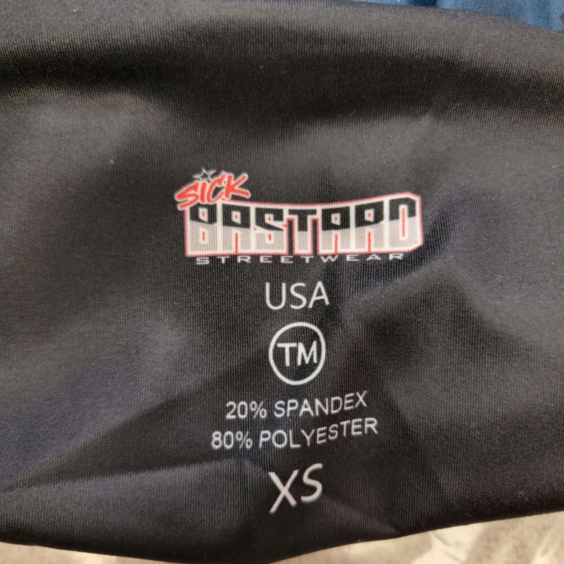 Label showing Sick Bastard Streetwear logo, fabric content, and size for patriotic leggings.