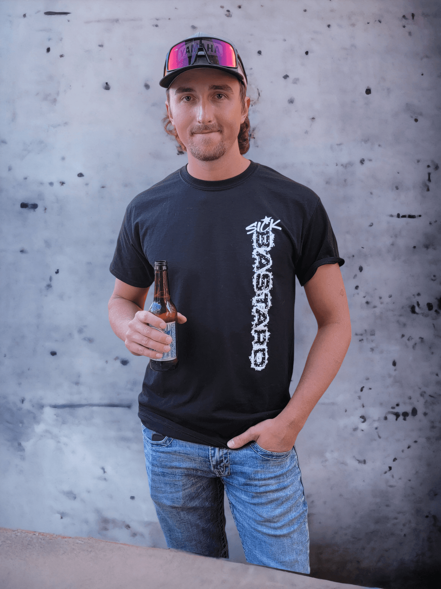 Man wearing a funny graphic t-shirt from Sick Bastard Streetwear, holding a beer against a textured background.