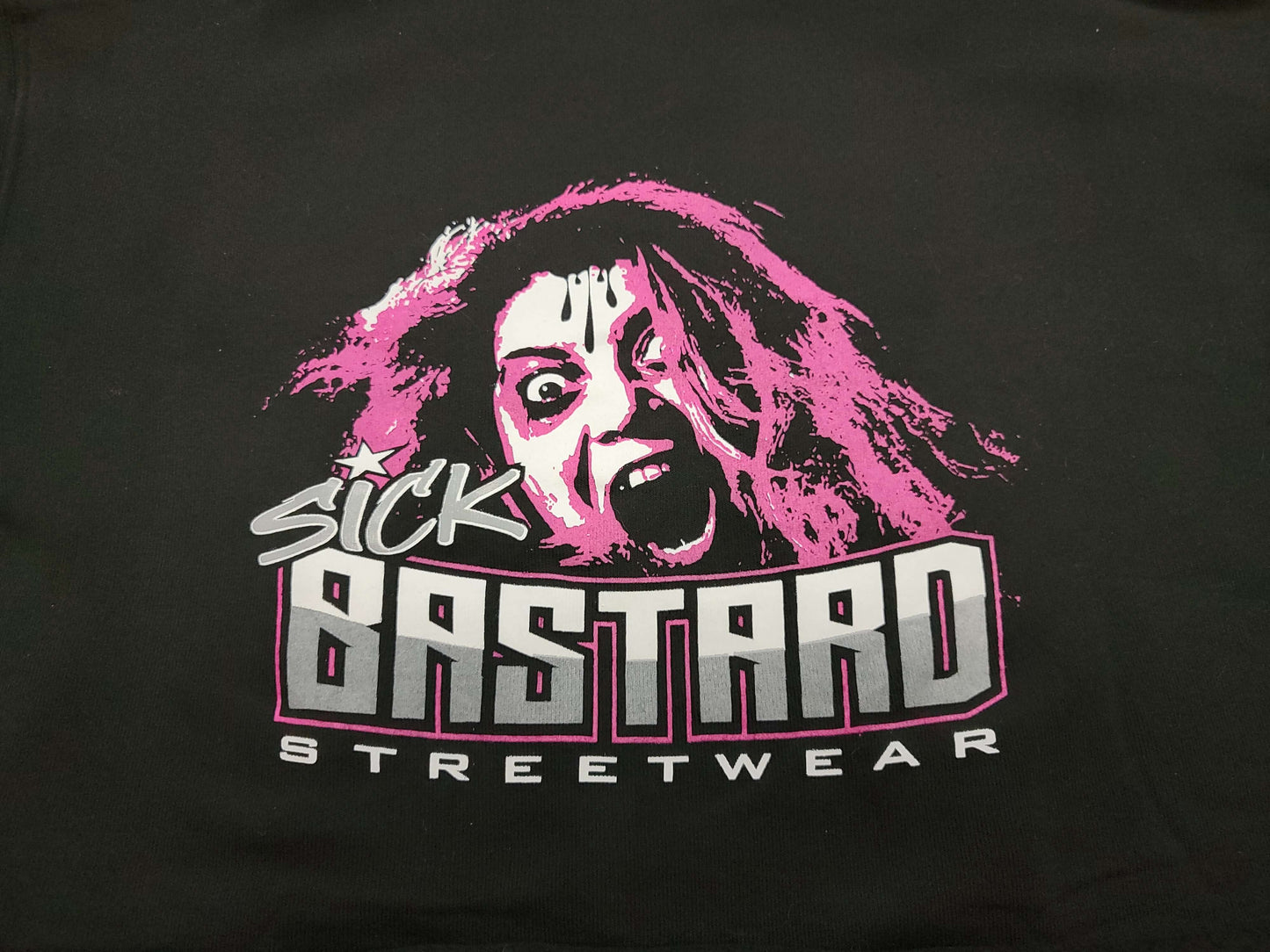 Graphic design of Sick Bastard Streetwear logo featuring a woman with wild hair and an expressive face.
