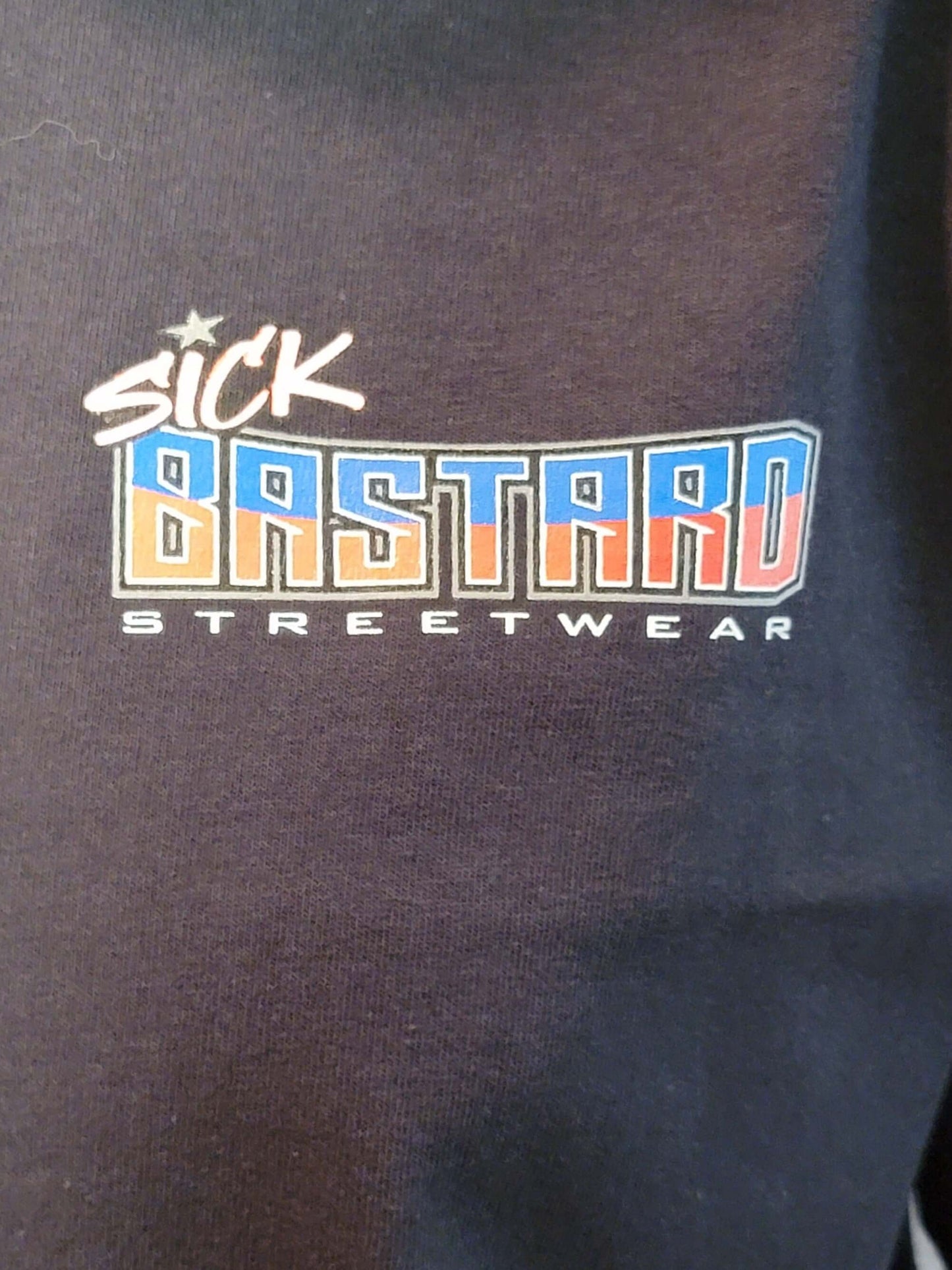 Sick Bastard Streetwear logo on a dark fabric, representing edgy fashion and lifestyle apparel.