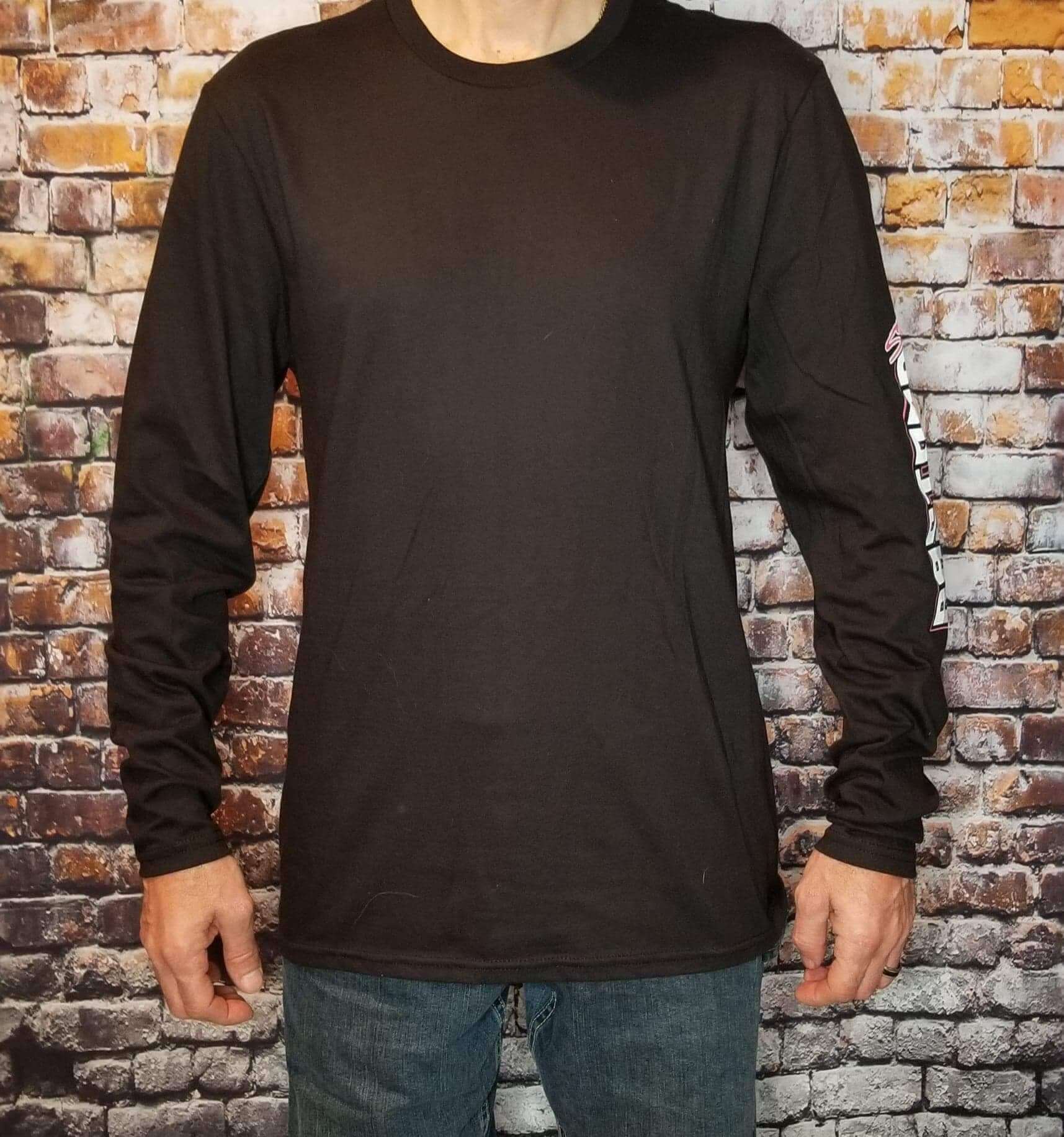 Freedom long sleeve shirt displayed on a male model against a brick wall background.